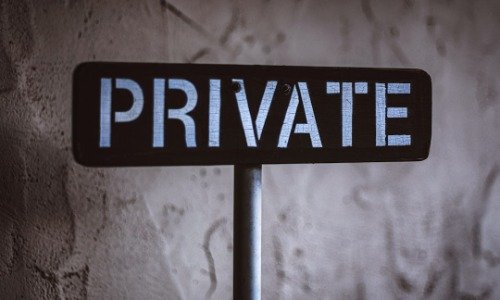 A black street sign with the word PRIVATE in white text.