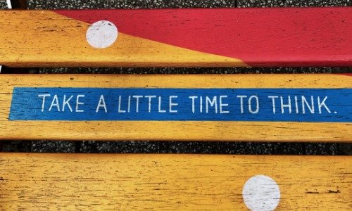 Sign on a bench that reads "Take a little time to think"
