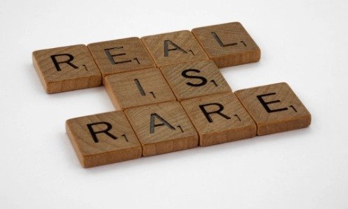 Scrabble letters spelling "Real is Rare"